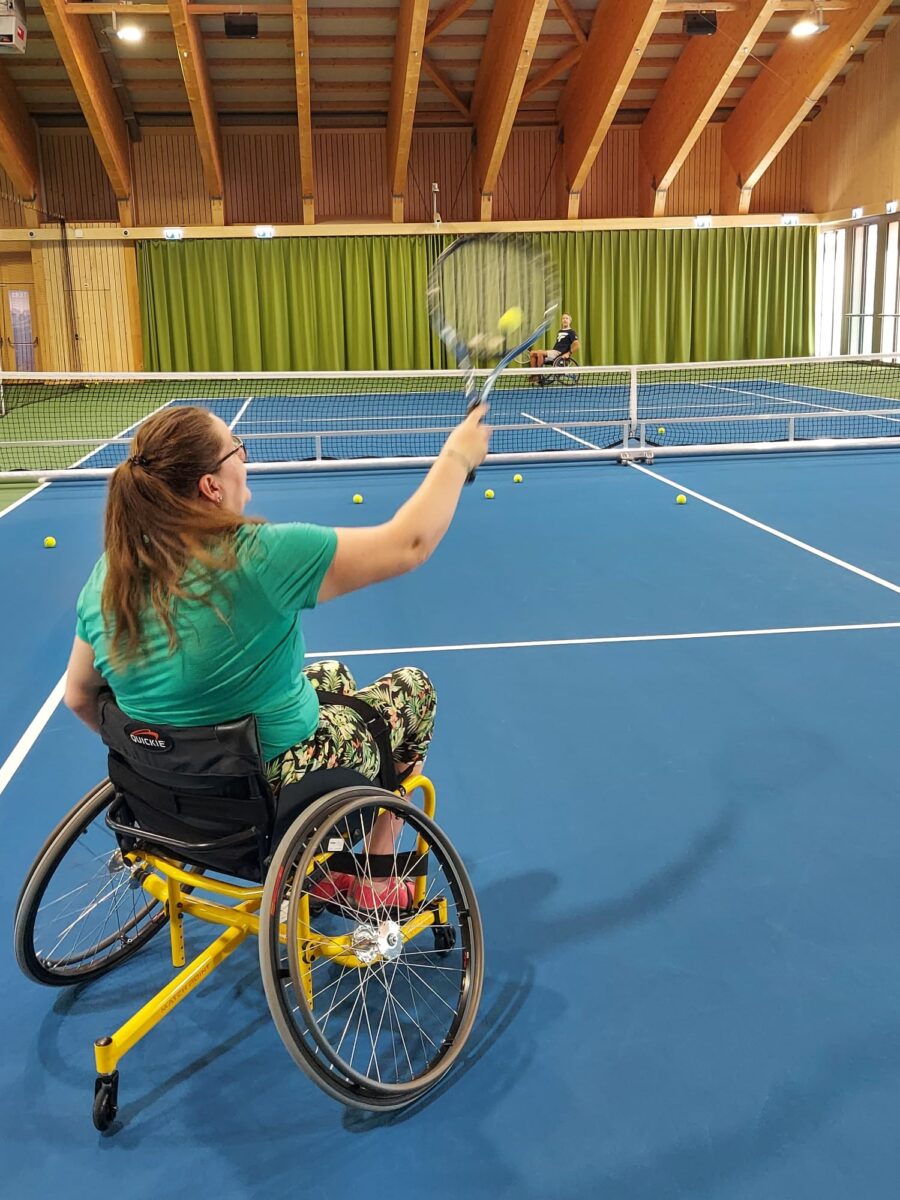 Dunna che gioga tennis ella sutga cun rodas speciala.